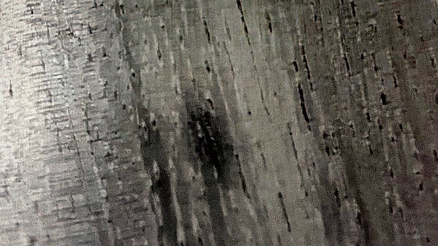 Close crop of honey-toned wood grain in window light.